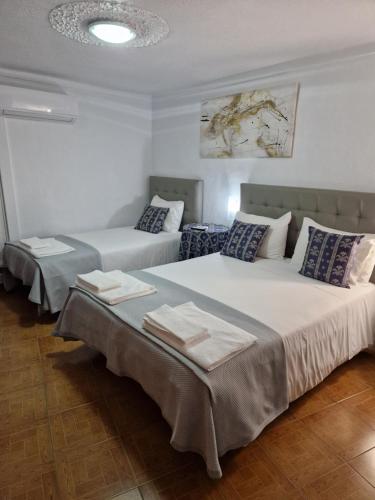a bedroom with two beds with towels on them at Residencial Antonio Mocisso Guesthouse in Elvas