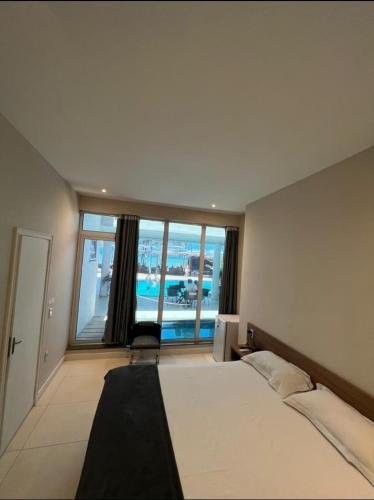 a bedroom with a large bed and a large window at ALIZE CUMBUCO in Cumbuco