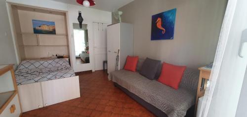 a living room with a couch and red pillows at Nice studio with terrace near the sea in Saint-Mandrier-sur-Mer