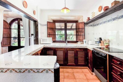 a kitchen with wooden cabinets and a white counter top at Villa Fonto in Pollença