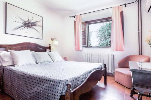 a bedroom with a bed and a chair and a window at Villa Fonto in Pollença