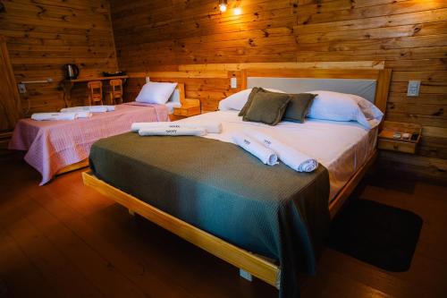 a bedroom with two beds in a log cabin at Cabañas complejo Ysyry Misiones in Puerto Victoria