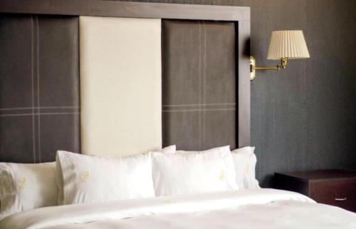 a bedroom with a large bed with white pillows at Hotel Real del Sur in Mexico City