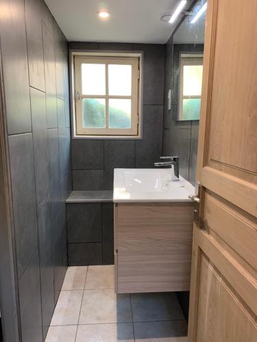 une petite salle de bain avec un lavabo et une fenêtre dans l'établissement Au Coeur des Châteaux, à Chambon-sur-Cisse
