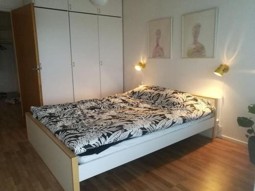 um quarto com uma cama com um cobertor preto e branco em Ylimmän kerroksen luksusnäkymät ydinkeskustassa em Uusikaupunki