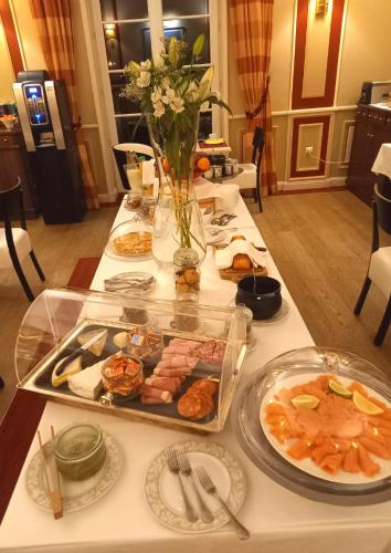 Una mesa con platos de comida sobre una mesa. en Le Domaine des Roches, Hotel & Spa, en Briare