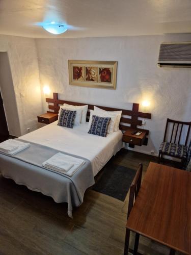 a bedroom with a large white bed and a table at Residencial Antonio Mocisso Guesthouse in Elvas