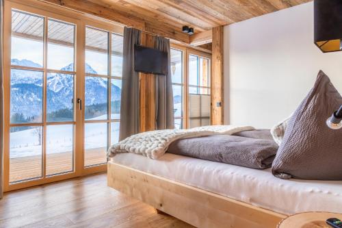 a bedroom with a bed and a large window at Chalet Schintlbauer in Annaberg im Lammertal