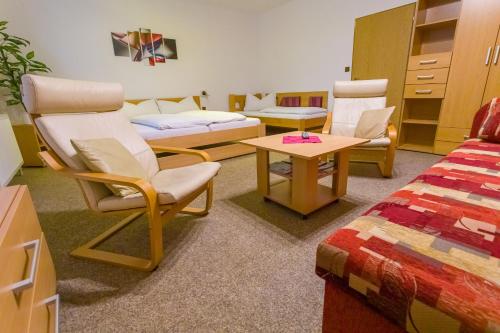 a room with chairs and a bed and a table at Pension Kraus in Litomyšl