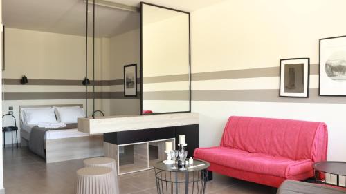 a living room with a pink couch and a bed at siviri suites in Siviri