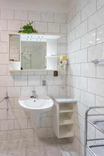 a white bathroom with a sink and a mirror at Pension Kraus in Litomyšl