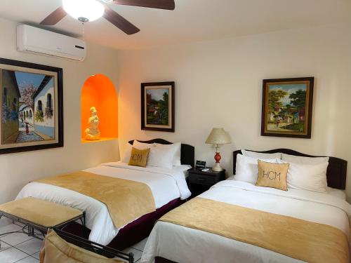 1 dormitorio con 2 camas y ventilador de techo en Hotel Camino Maya, en Copan Ruinas