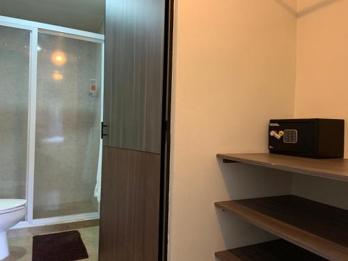 a bathroom with a toilet and a glass shower door at Star Suites México in Mexico City