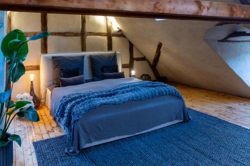 um quarto com uma cama grande e um cobertor azul em N5Quartier em Bad Münstereifel