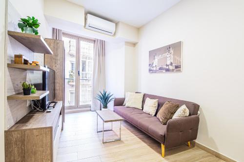 salon z kanapą i telewizorem w obiekcie CartagenaFlats - Apartamentos Turísticos Jabonerías 16, CITY CENTER w mieście Cartagena