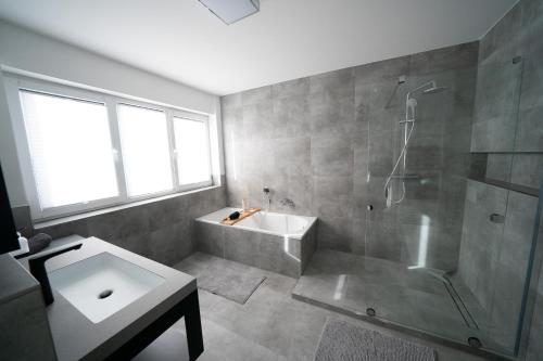 a bathroom with a shower and a tub and a sink at Villa Emma in Osnabrück