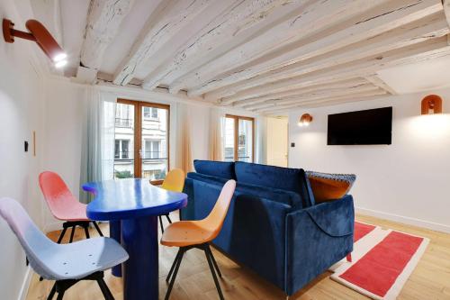 a living room with a blue couch and a table and chairs at Joyful apartment 2BR6P Heart of Paris - Louvre in Paris