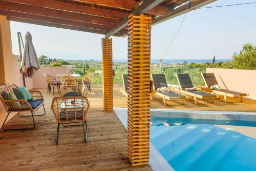 a patio with a pool and chairs and a table at Villa de la Vita in Katastárion