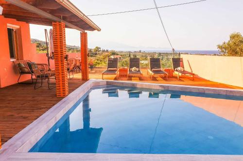a swimming pool with chairs and a house at Villa de la Vita in Katastárion