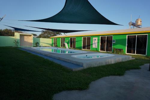 a building with a swimming pool in front of it at Velaria in Chachalacas