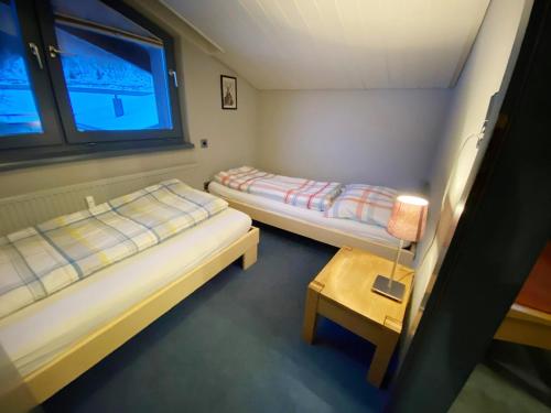 ザンクト・アントン・アム・アールベルクにあるSt Anton ski apartmentsのベッド2台、テーブル、窓が備わる客室です。