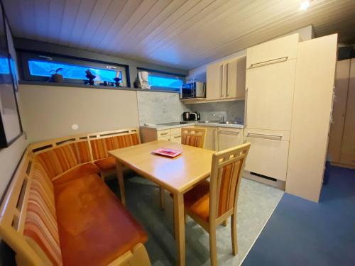 St Anton ski apartments في سانكت أنتون ام ارلبرغ: مطبخ صغير مع طاولة وكراسي خشبية