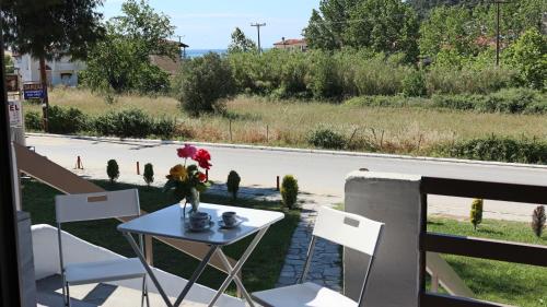 a table with a vase of flowers on a balcony at siviri suites in Siviri