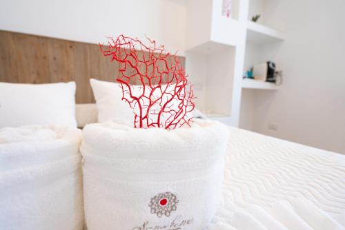 a stack of towels sitting on a bed at Sunshine Charming Houses in Alghero