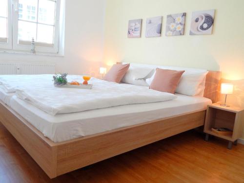 Una gran cama blanca con una bandeja de comida. en Blankwasserweg 51, Whg 5 - Wohnung mit Strandkorb nur 5 Minuten zum Strand, en Grömitz