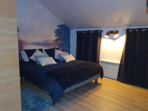 una camera con letto blu e cuscini di La maison des galeries classé 4 étoiles a Fécamp