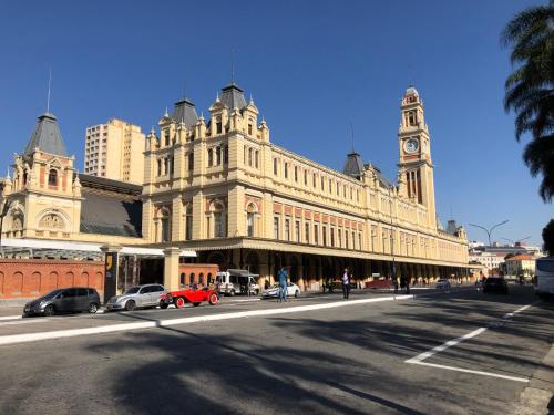 a large building with a clock tower on a street at Residencial Bella Vista Suites in Sao Paulo