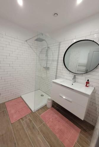 une salle de bain blanche avec un lavabo et un miroir dans l'établissement Charmant petit logement à 3 kms de la plage, à Belgodère