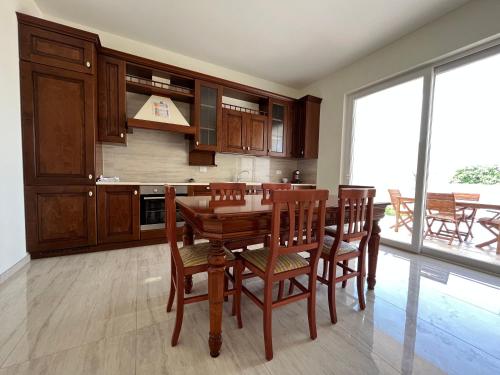 a kitchen with a wooden table and chairs at Salento Appartamento Sole in Marina di Mancaversa