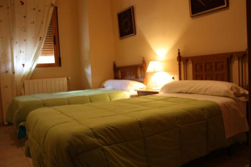 two beds in a hotel room with two beds at Casas Rurales Fuenmayor in Torres
