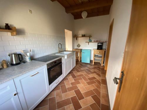 a kitchen with white cabinets and a tile floor at Am Kaisersteig in Zwiesel