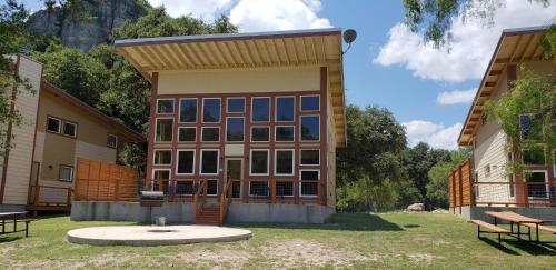 a building with a lot of windows in a yard at Seven Bluff Cabins in Concan