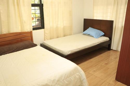 1 Schlafzimmer mit 2 Betten und einem Fenster in der Unterkunft Casa del Rio in La Cumbre