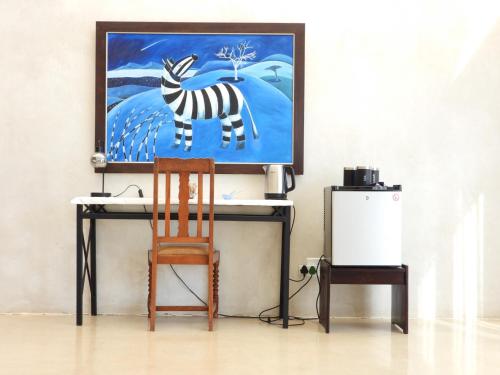 a desk with a chair and a painting of a zebra at Ibenstein Safaris in Dordabis