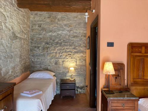 a bedroom with two beds and a stone wall at La Busca Country House in Monte Benedetto
