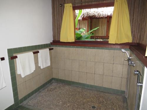 baño con ducha y toallas y ventana en Maningory, en Ile aux Nattes