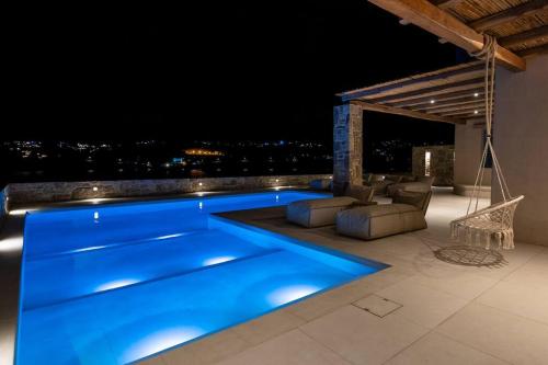 una grande piscina blu su un tetto di notte di Villa Myko by Bestofmikonos a Mykonos Città
