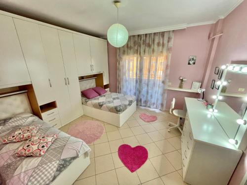 a bedroom with two beds and a sink with hearts on the floor at Superb Apt Central in Durrës