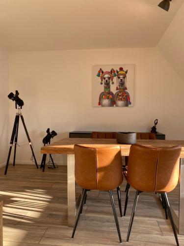 a dining room with a table and two dogs on the wall at Ferienwohnung Haus Ossenkopp in Dümmer