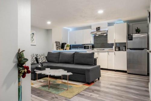 a living room with a couch and a kitchen at Cozy nest basement unit in Hamilton