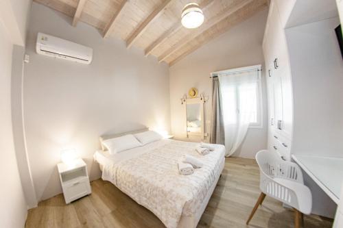 a white bedroom with a bed and a desk at Corfu Cicada House in Corfu Town