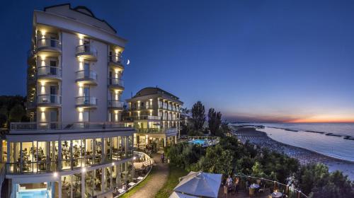 a hotel with a view of the ocean at night at Hotel Sans Souci in Gabicce Mare