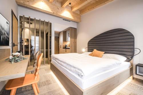 a bedroom with a large bed and a desk at Alpine Collection Wildschönau am Paraglidinglandeplatz Markbachjoch, Nähe Skiwelt Wilder Kaiser - Brixental in Niederau