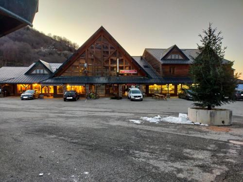 a large lodge with cars parked in a parking lot at Guzet Neige 1400 in Ustou