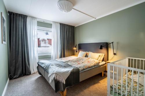 DomsjöにあるSpacious Villa located in Beautiful High Coastのベッドルーム1室(ベッド1台、ベビーベッド1台、窓付)
