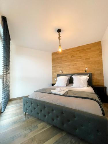 a bedroom with a large bed with a wooden headboard at Easy Location - Parking - Free Wifi - Tourism and Business in Freyming
